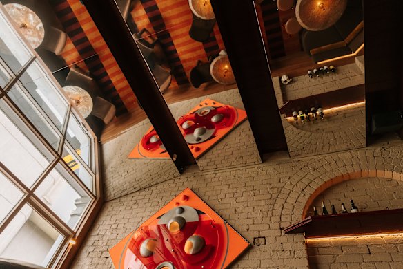 Angled ceiling mirrors reflect the retro-inspired fitout by Bergman &amp; Co.