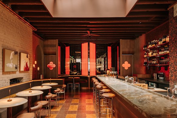 Steel-legged furniture and red lights add to the glossy feel.