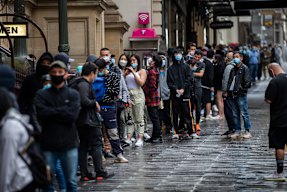 Long lines of people wanting to get vaccinated against COVID-19 are seen at Melbourne Town Hall on Friday.