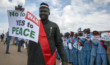 South Sudanese people hold signs as talks to end the five-year civil war were under way.