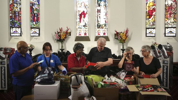 Reverend Bill Crews and volunteers of the Exodus Foundation sort through Christmas donations at their Ashfield parish prior to Chrismas Day. 