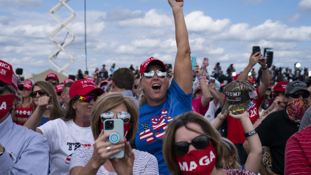 Supporters of President Donald Trump cheer as he arrives to speak at a campaign rally at Pitt-Greenville Airport in Greenville, NC. 