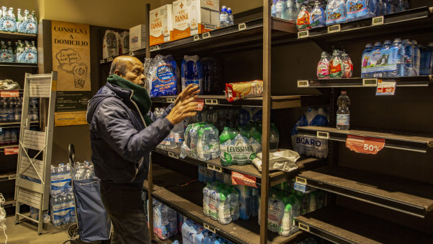 A man buys supplies of bottled water in Milan, Italy.