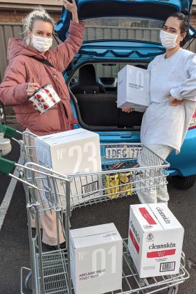 Sarah Seymour and Abbey Sutton load up on wine in case of a mass closure of bottle shops.