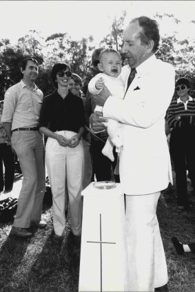 Ted Noffs of the Wayside Chapel performs a naming ceremony in a flared white suit in 1982.