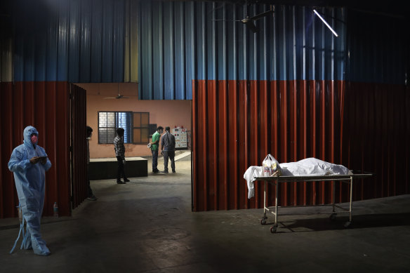 Workers prepare to cremate the body of a COVID-19 victim in New Delhi on Monday.