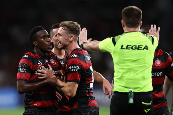 Yeni Ngbakoto is restrained by teammates after being sent off by referee Adam Kersey.