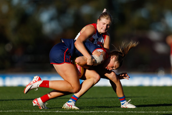 Tayla Harris of the Demons is tackled by Isabelle Pritchard.