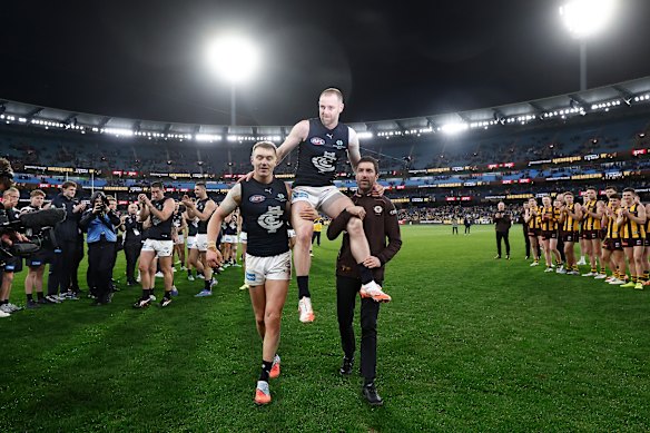Sam Docherty of the Blues is chaired from the field after his final game by Patrick Cripps of the Blues (left) and Kade Simpson.