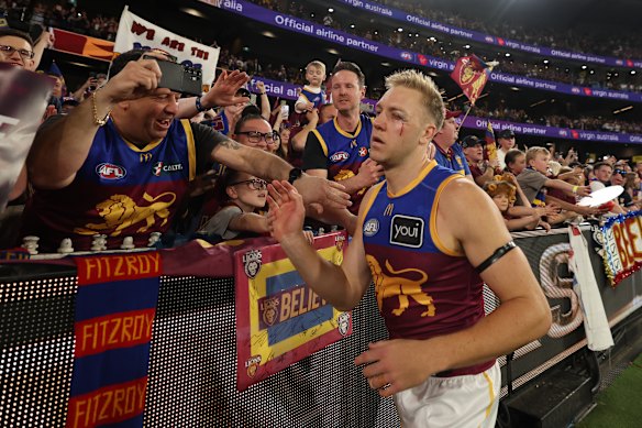 Battered and bruised, Oscar Allen laps up the love of the Brisbane Lions faithful.