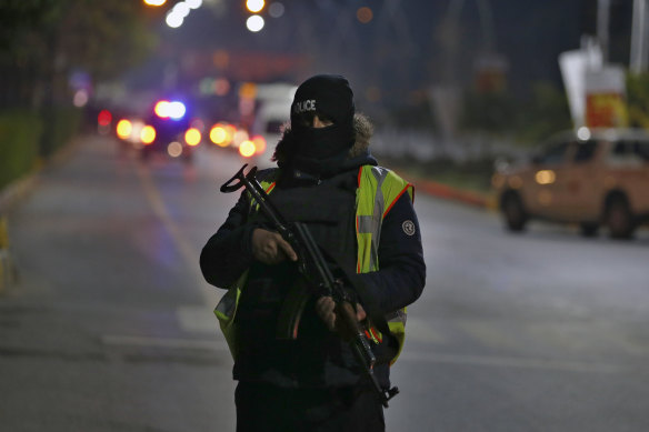 A police commando stands guard while  the Australian cricket team is ferried to their hotel in Islamabad.
