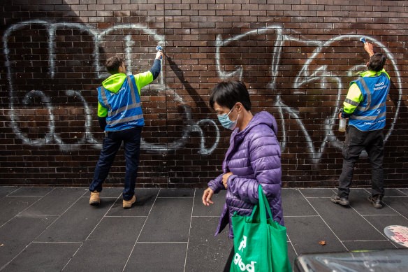 City of Melbourne workers clean off  tagging graffiti near the corner of Little Bourke and Russell streets. 