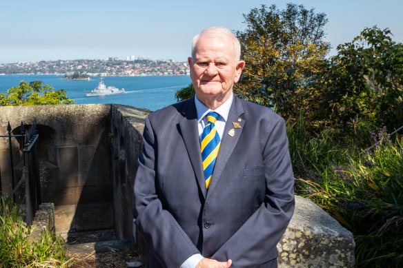 The just retired NSW RSL president Ray James with the HMAS Brisbane (III) on the harbour behind him with his grandson on board heading for the South China Sea.