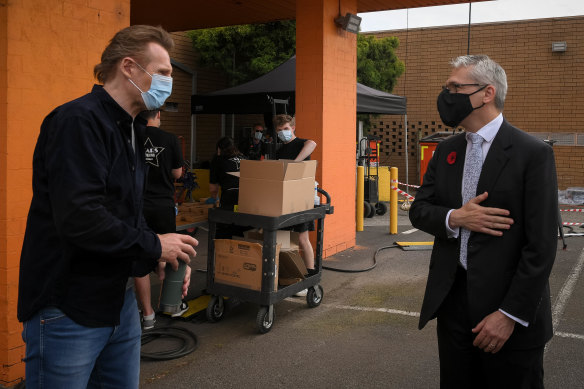 Masked men: Neeson, left, with Creative Industries minister Danny Pearson. 