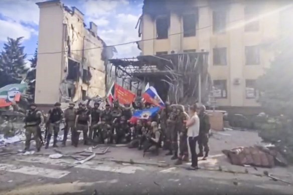 Russian troops and Chechen soldiers pose of a photo in Lysychansk, Ukraine on Sunday as Russia claimed the city.