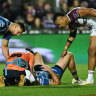 Shaun Lane receives treatment after a tackle from Haumole Olakau’atu and Daly Cherry-Evans.