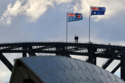 The flags of NSW and Australia atop the Sydney Harbour Bridge.