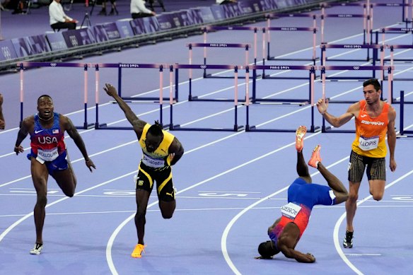 Grant Holloway, left, of the US wins the men’s 110-metre hurdles final as teammate Daniel Roberts takes a tumble at the line.