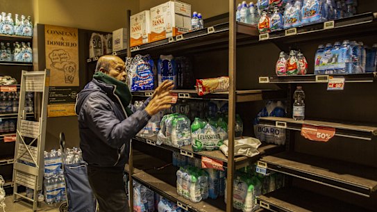 A man buys supplies of bottled water in Milan, Italy.