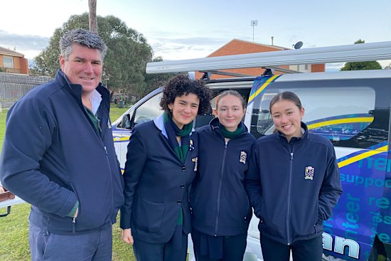 St Leonard’s College principal Peter Clague with student volunteers who rode in Lennie’s Van to prepare breakfast for residents at a local council estate.
