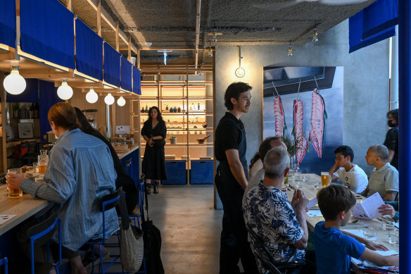 Bright blue noren (bunting) surrounds the bar counter.