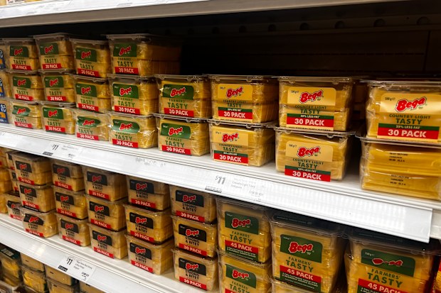 Packets of cheese on a supermarket shelf in the chilled section.