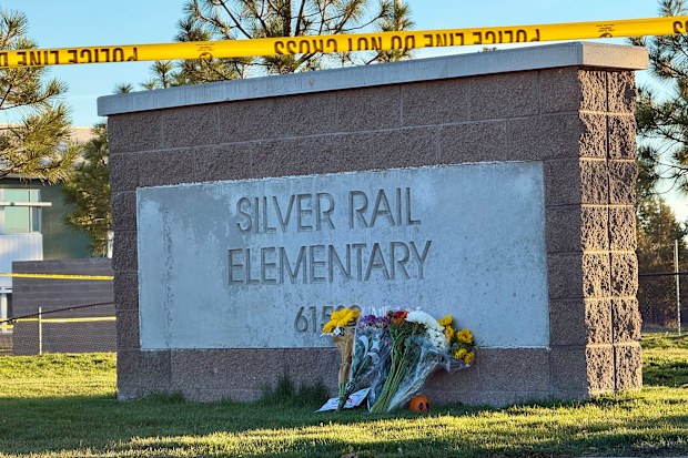Flowers are placed beside a sign at Silver Rail Elementary School in Bend, Ore., on Friday, Oct. 16, 2026, a day after a deadly shooting. (AP Photo/Haven Daley)