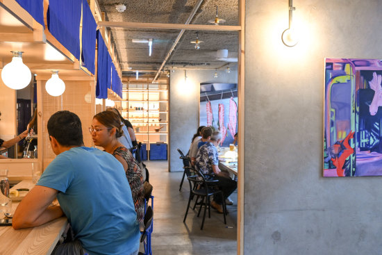 Bright blue noren (bunting) surrounds the bar counter.