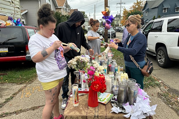 People gather at a memorial outside the home where authorities say a gunman killed several people including members of his own family before killing himself