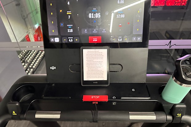 Reporter Maddison Skipper reads a Kindle while walking on the treadmill at her local gym.
