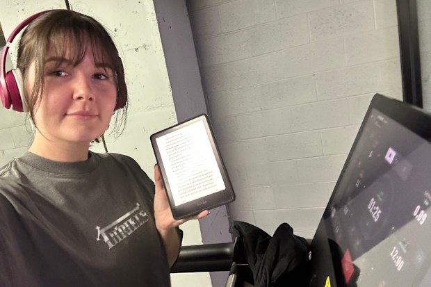 Reporter Maddison Skipper reads a Kindle while walking on the treadmill at her local gym.