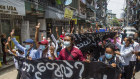 Anti-coup protesters hold a banner that reads “What are these? We are Yangon residents!” as they march during a demonstration on Tuesday.