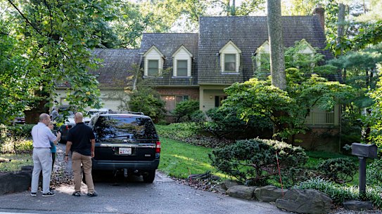 Police outside John Bolton’s house as FBI agents search the premises.