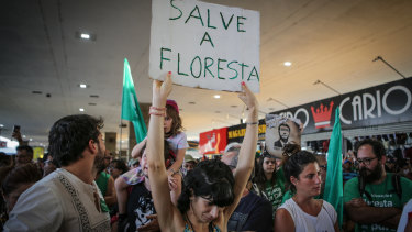 Demonstrators hold signs while gathering during an Amazon in the Streets protest in Brazil. 