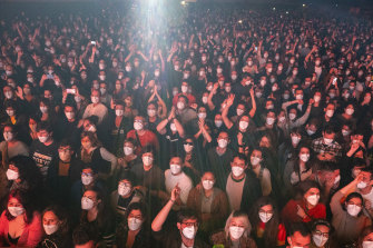 People using face masks take part in a music concert in Barcelona, Spain.