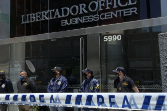 Police stand guard the entrance of Dr Leopoldo Luque's practice in Buenos Aires, Argentina, on Sunday.