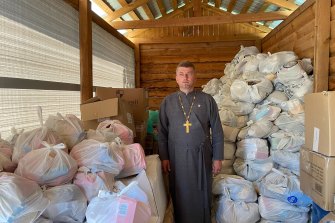 Father Dmytro with food and other basic supplies in the storeroom next to his church in Borodyanko.