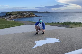 The Phantom Rabbitoh checking one of his stencilled Rabbitohs, which have been painted all across Sydney in the lead up to the NRL grand final.
