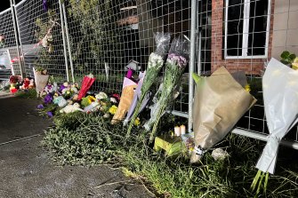 Floral tributes and children’s stuffed toys were left outside the home on Sunday night.