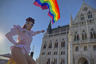 A drag queen waves a rainbow flag outside Hungary’s parliament last year.