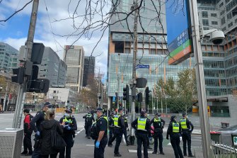 Police attend an anti-lockdown protest in the city on Saturday.