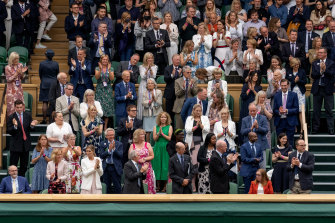 Royals and spectators stand for Oxford Professor Sarah Gilbert (seated in red, bottom right) on the opening day of Wimbledon. 