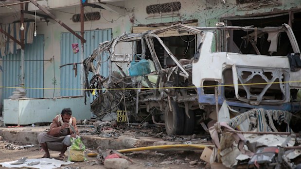 A man inspects the wreckage of a bus at the site of a deadly Saudi-led coalition airstrike in Saada, Yemen.