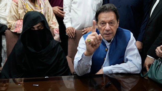 Pakistan’s former Prime Minister Imran Khan, right, and Bushra Bibi, his wife, talk to the media in July 2023.