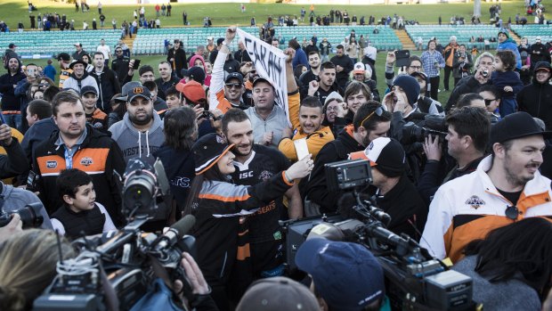 Emotional scenes: Robbie Farah is mobbed by fans following his appearance in a NSW Cup clash at Leichhardt in 2016. It was the beginning of the end for Farah at the Tigers.