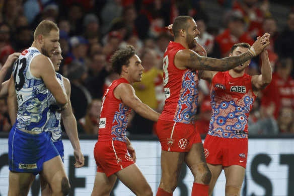 Swans star Lance Franklin celebrates with teammates after kicking his third goal against the Kangaroos.