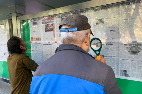 Yao, a retired carpenter in Beijing reads newspapers in the street on Wednesday. 