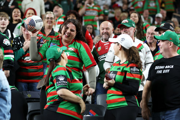 A supporter celebrates securing a football in the crowd.