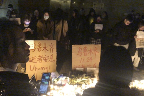 Demonstrators stand by protest signs in Shanghai on Saturday.