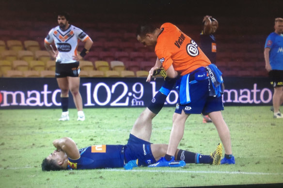 Play is stopped while Gold Coast centre Young Tonumaipea receives urgent treatment for cramp.